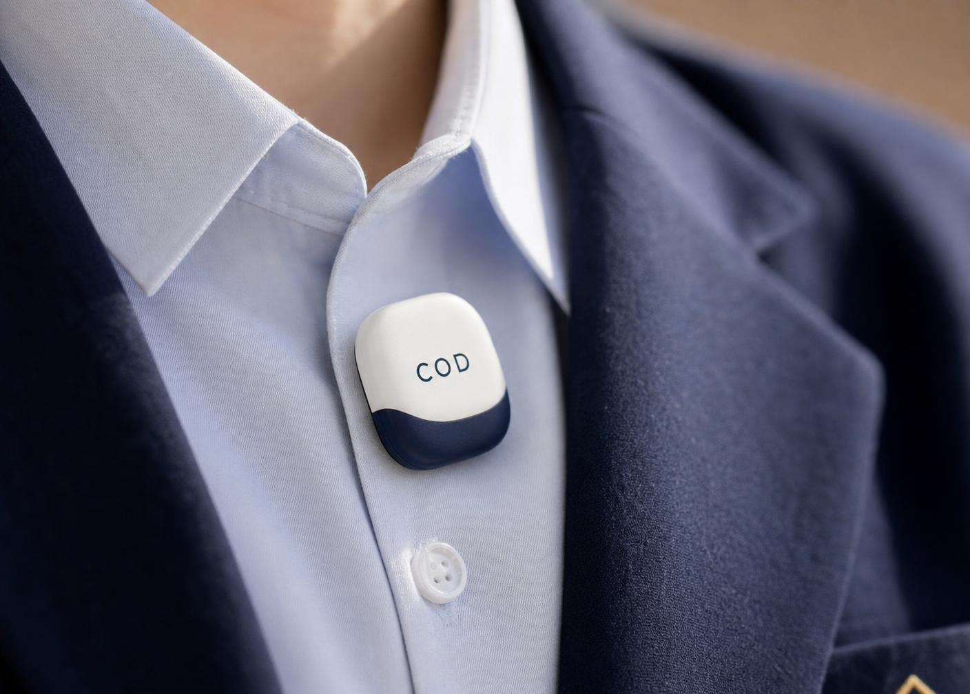 Close-up of the small COD badge clipped to the chest of a school uniform